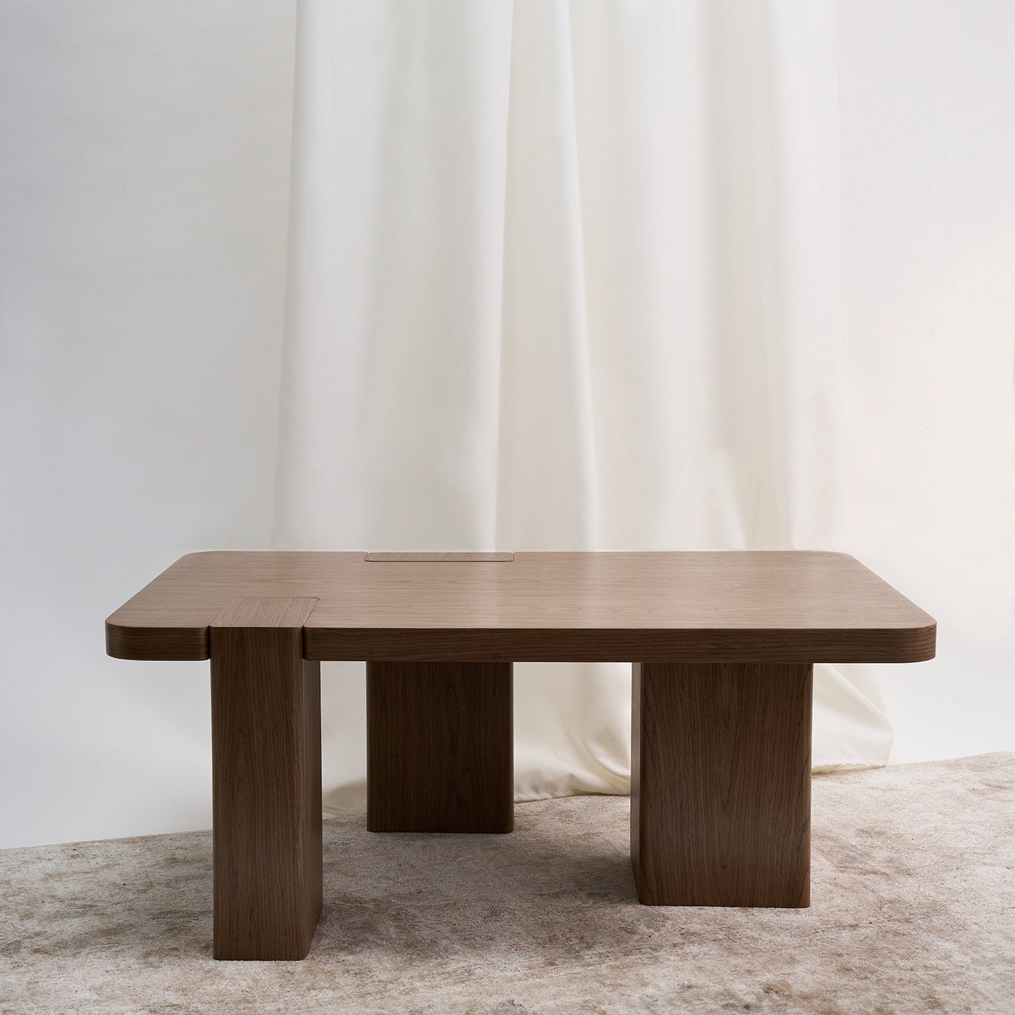 Una mesa de centro que se aparta de lo convencional para convertirse en un verdadero hito dentro del espacio. Color nuez.