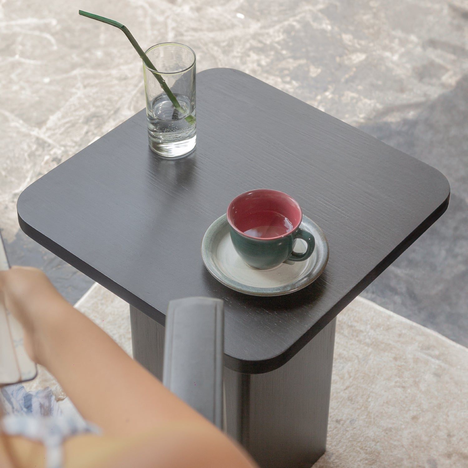 Mesa con una estructura ortogonal que se suaviza con sutiles curvas en el tablero y la base, creando una sensación de armonía. Color carbón.