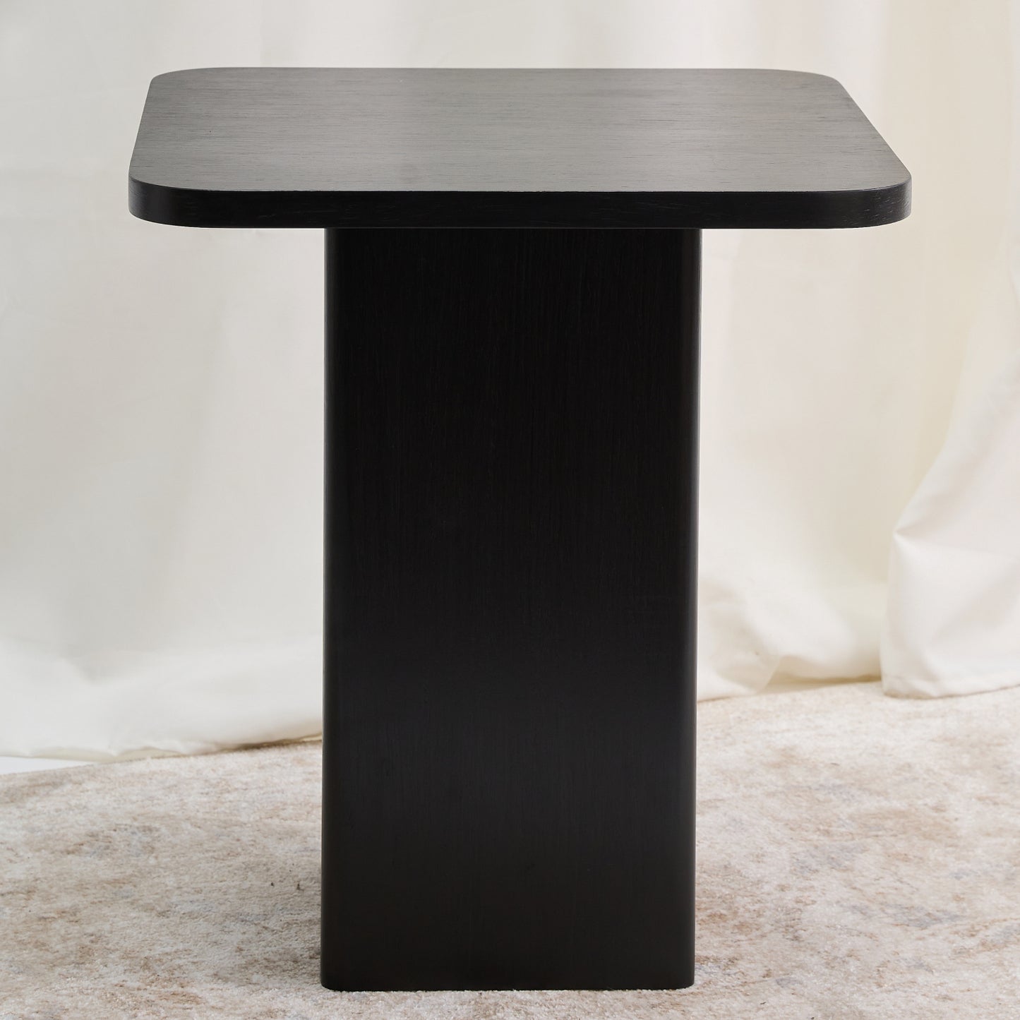 Mesa con una estructura ortogonal que se suaviza con sutiles curvas en el tablero y la base, creando una sensación de armonía. Color carbón.