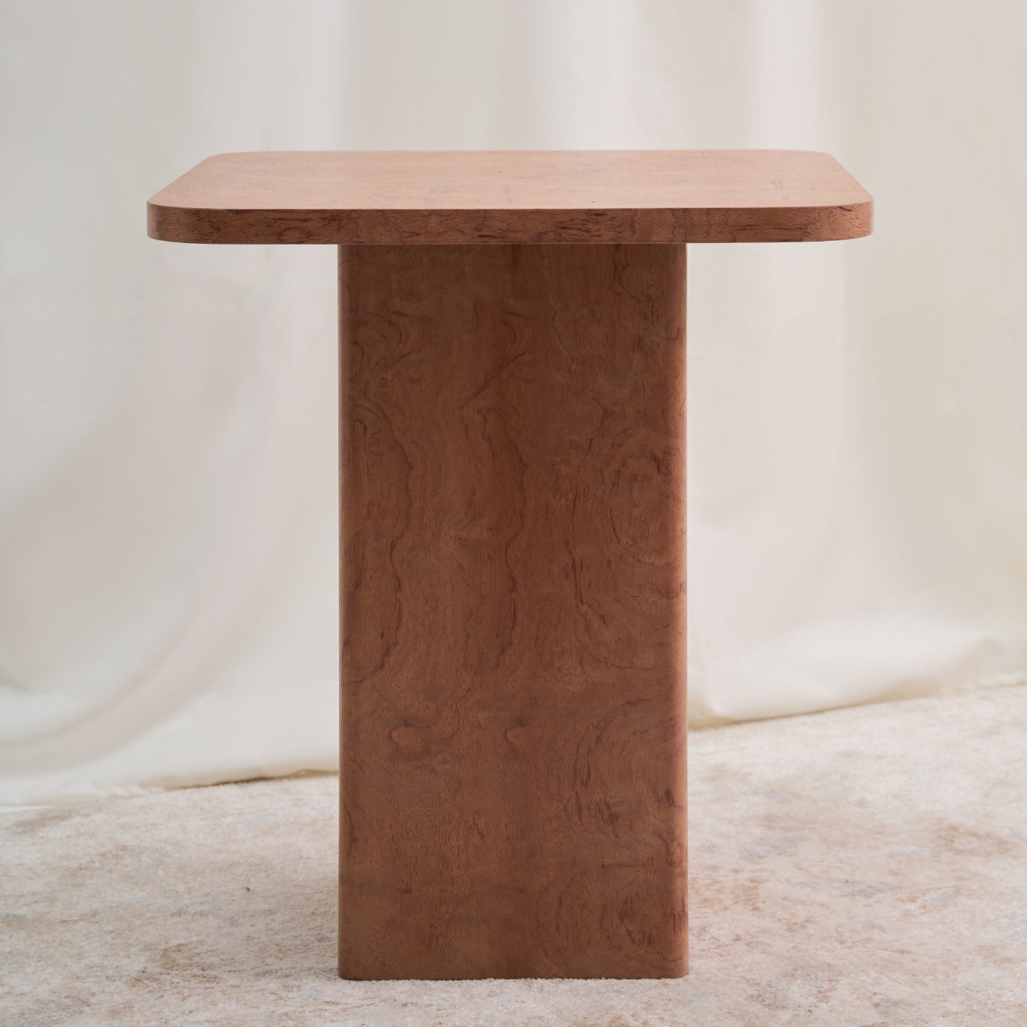 Mesa con una estructura ortogonal que se suaviza con sutiles curvas en el tablero y la base, creando una sensación de armonía. Color ocre.