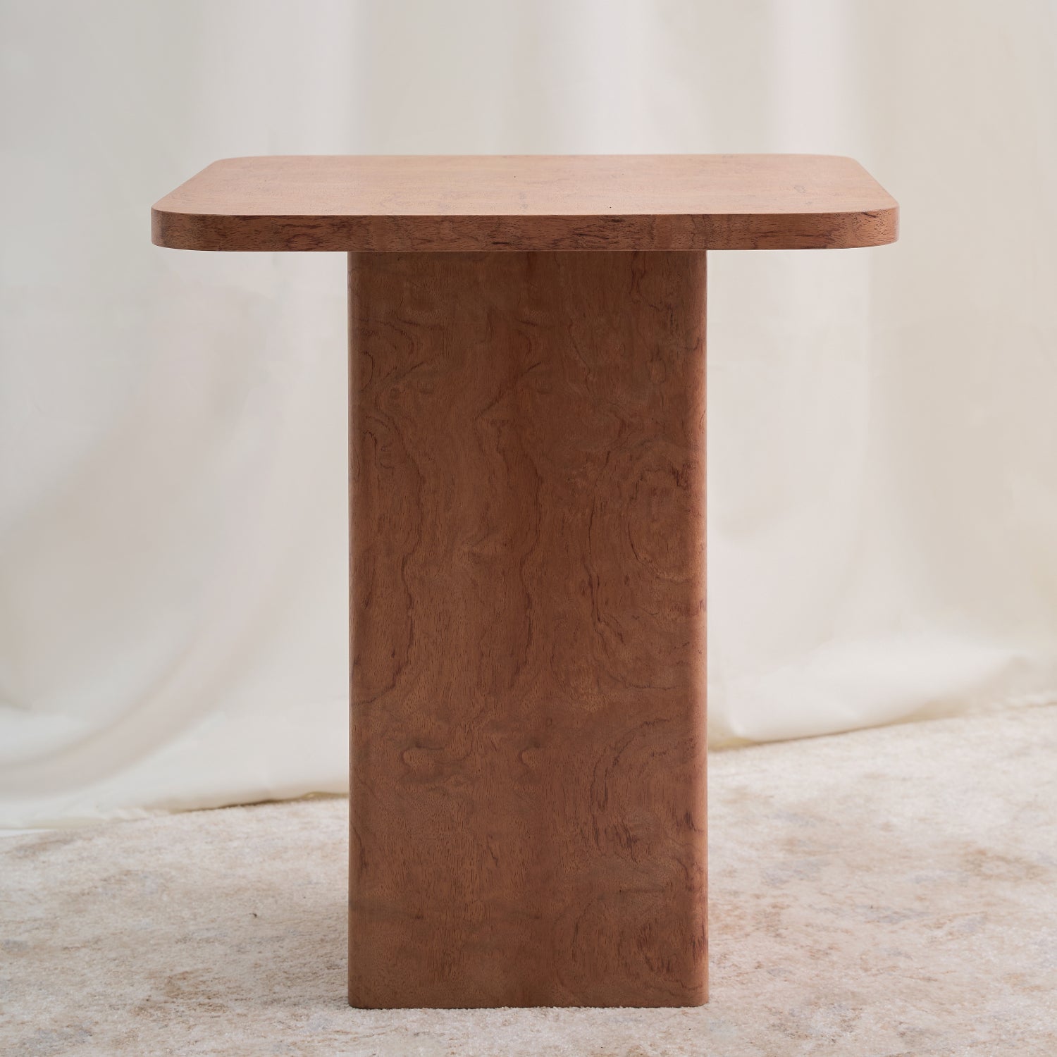 Mesa con una estructura ortogonal que se suaviza con sutiles curvas en el tablero y la base, creando una sensación de armonía. Color ocre.