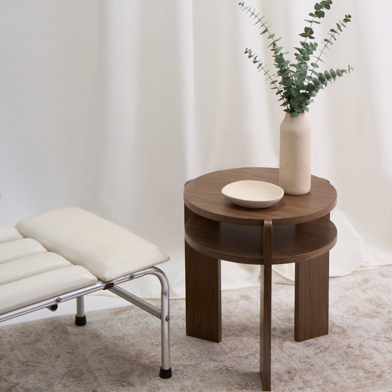 Mesa con un diseño combina geometría circular y estructura vertical con una precisión que sorprende por su simplicidad. Color nuez.