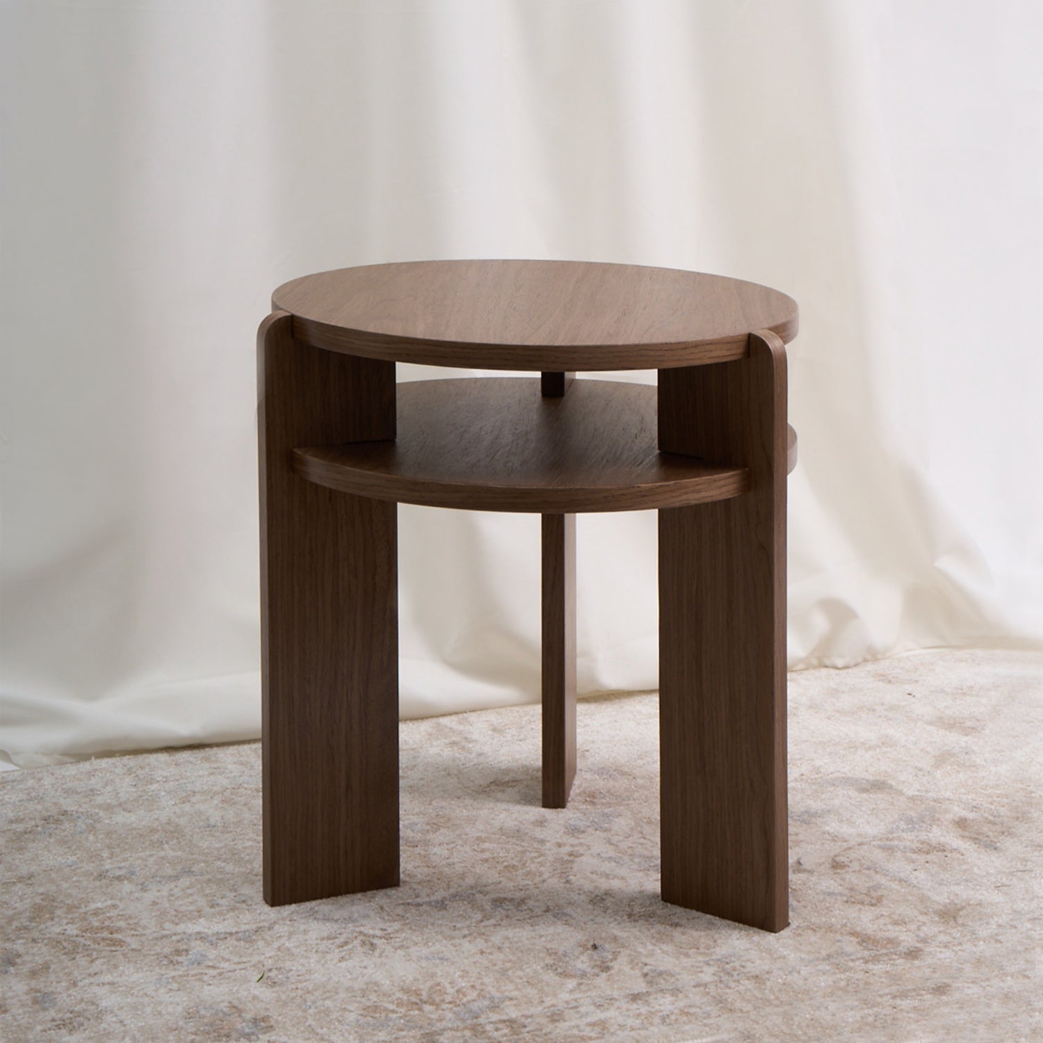 Mesa con un diseño combina geometría circular y estructura vertical con una precisión que sorprende por su simplicidad. Color nuez.